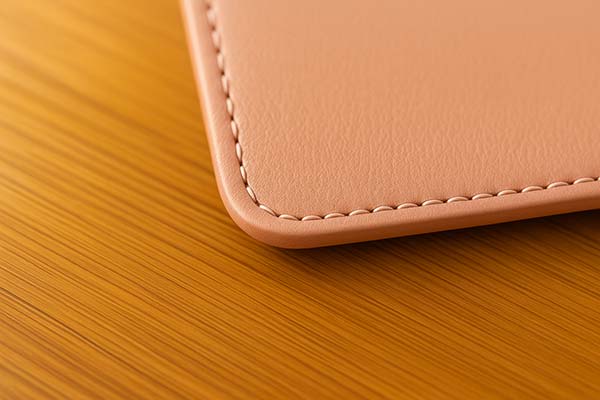 ピンクのランドセルのステッチ部分をクローズアップした写真。白い縫い目と革の質感が上品に際立っている。