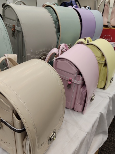 展示会で複数カラーのランドセルを比較している様子