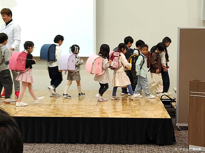 ランドセル合同展示会でランドセルを背負って歩く子どもたちの様子
